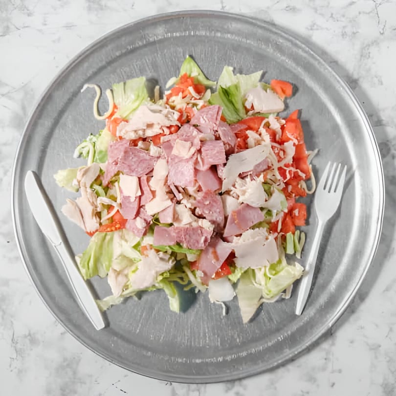 A large Pointer's Pizza chef salad with lettuce, tomatoes, cheese, ham, salami, and turkey.